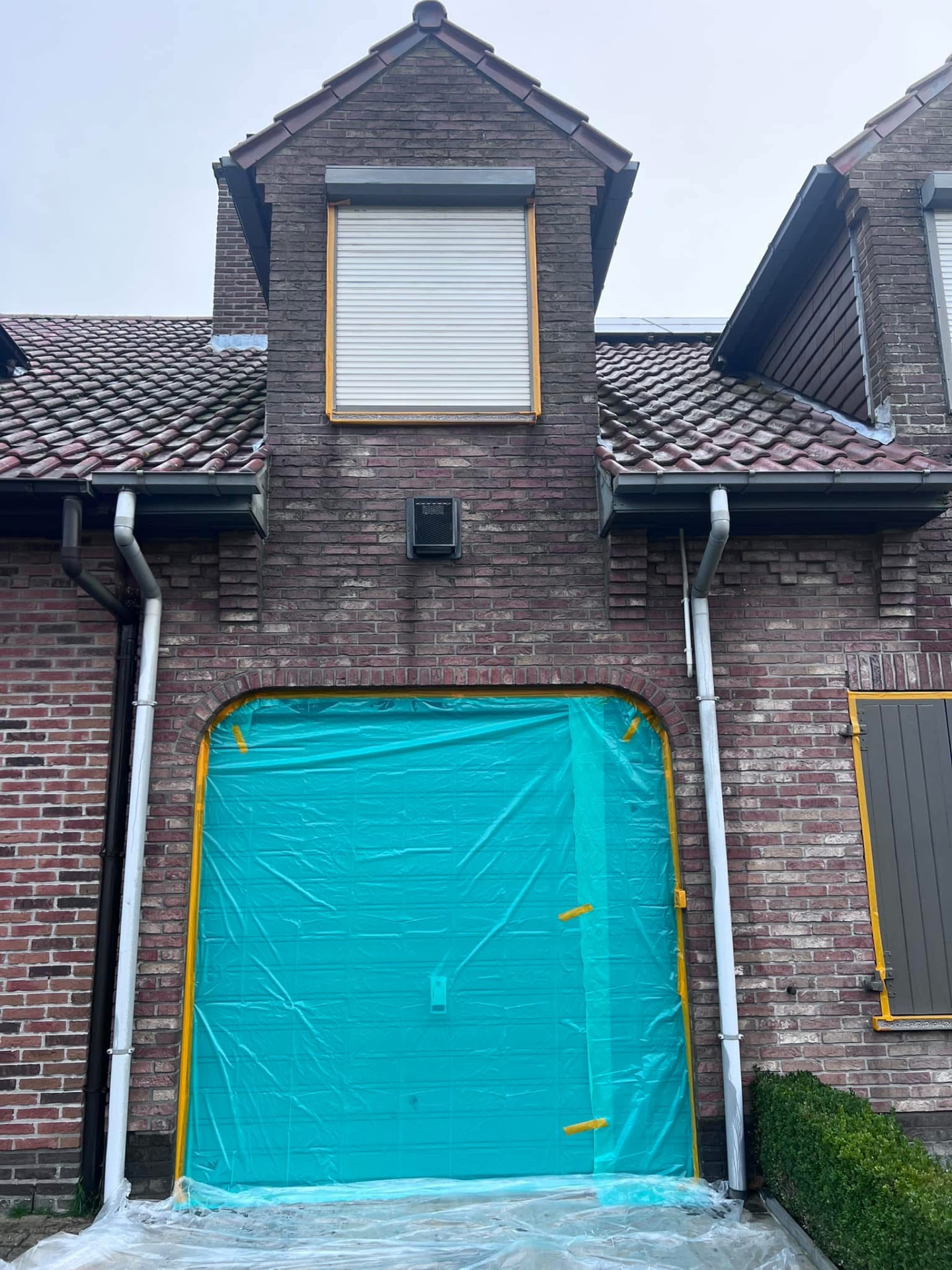Zorgvuldig afplakken van garagepoort voor impregnatie